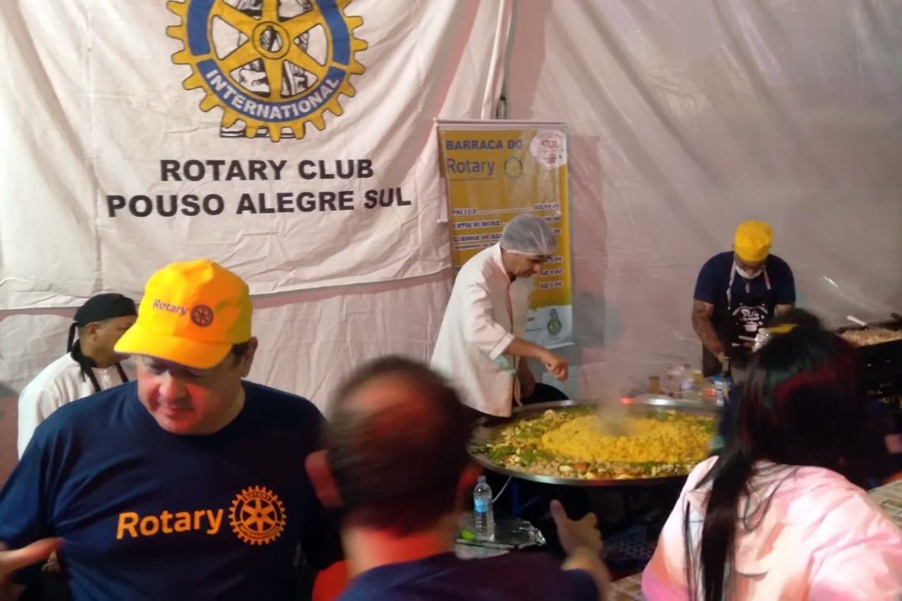Um grupo de pessoas em frente a uma faixa que diz Rotary Club