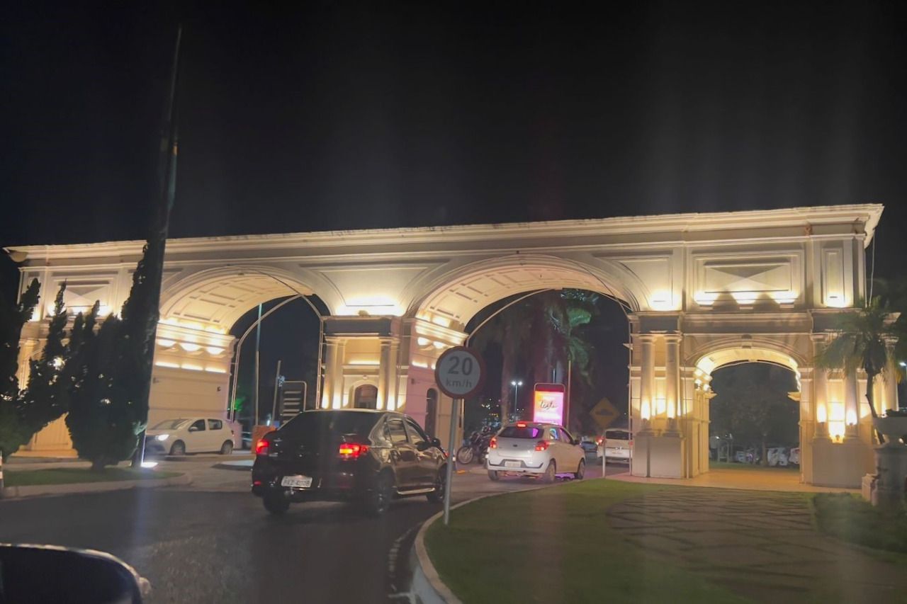 Um grupo de carros está estacionado em frente a um prédio à noite.