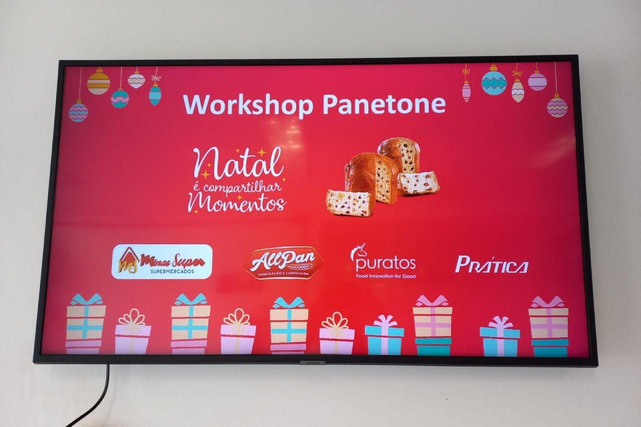 Uma grande tv de tela plana está exibindo um panetone de oficina