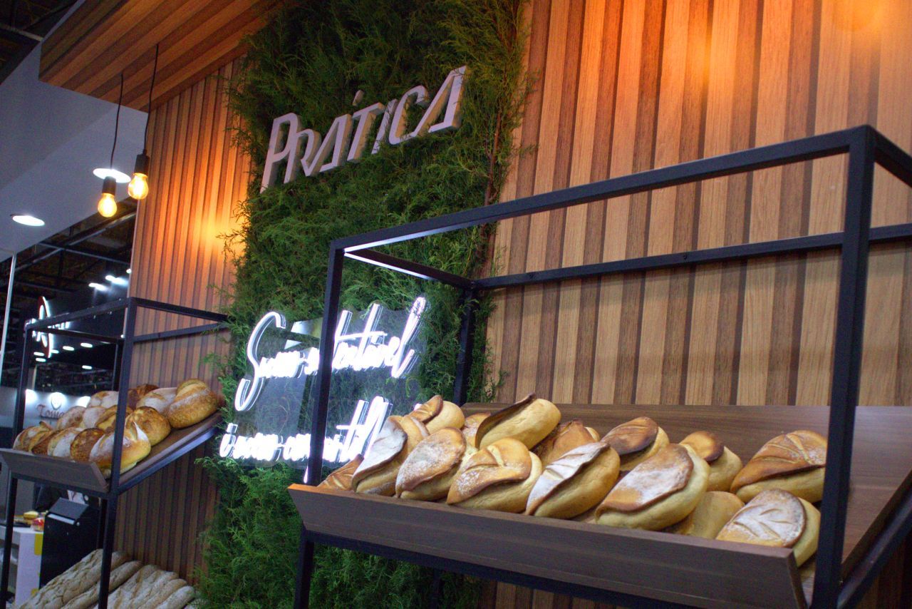 Um monte de pão está em uma prateleira em uma padaria.