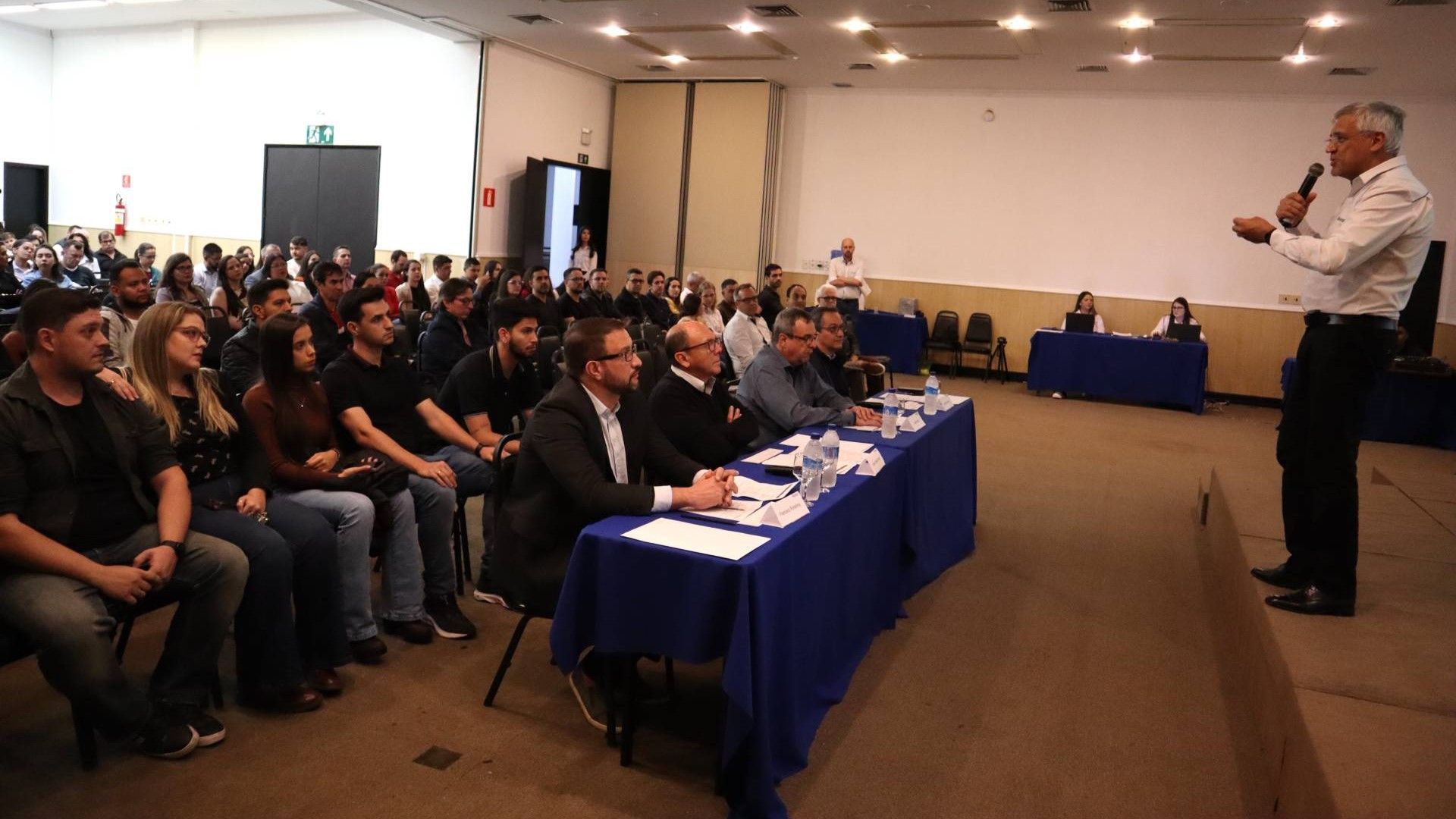 Um homem está fazendo uma apresentação para um grande grupo de pessoas