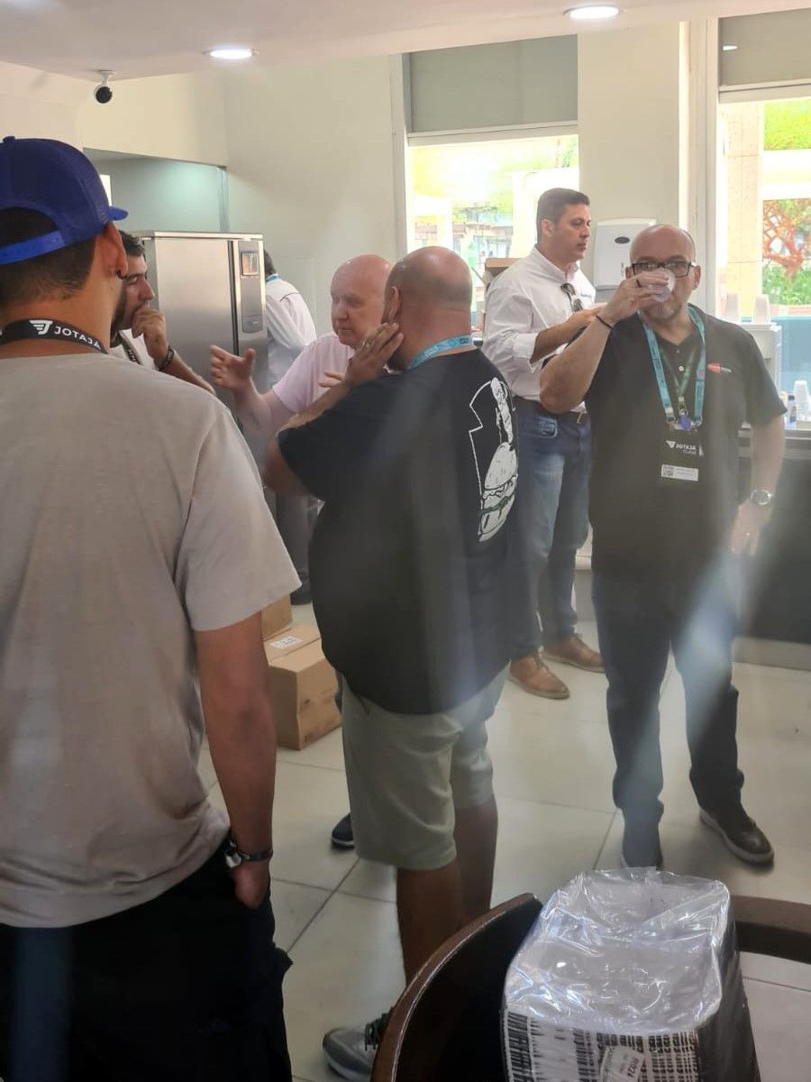 Um grupo de homens estão em uma sala conversando entre si