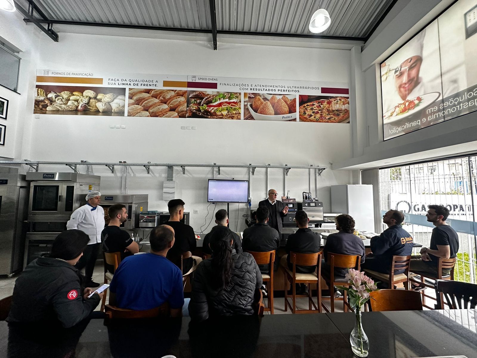 Um grupo de pessoas está sentado ao redor de uma mesa em um restaurante.