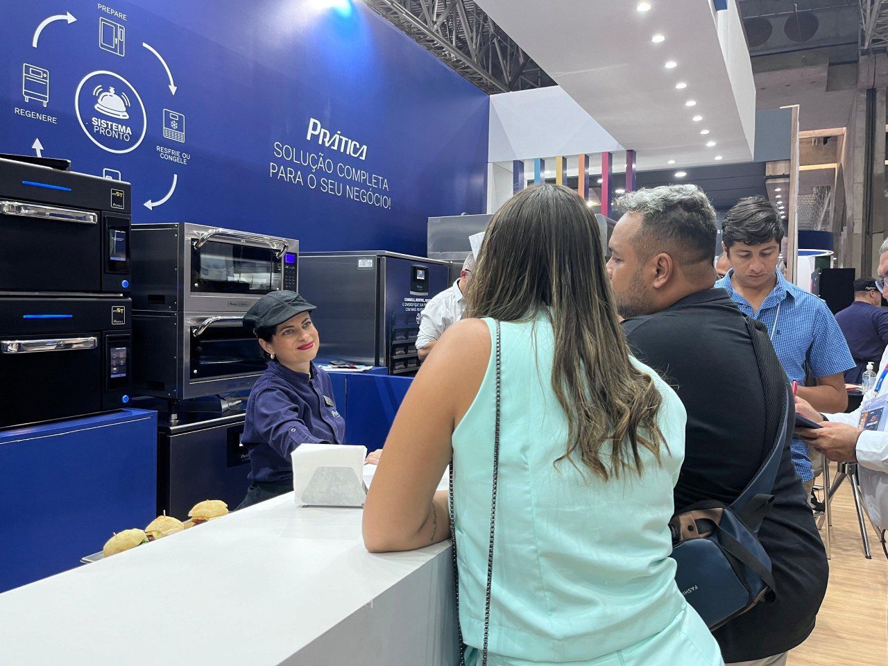 Um grupo de pessoas está sentado no balcão de um restaurante.