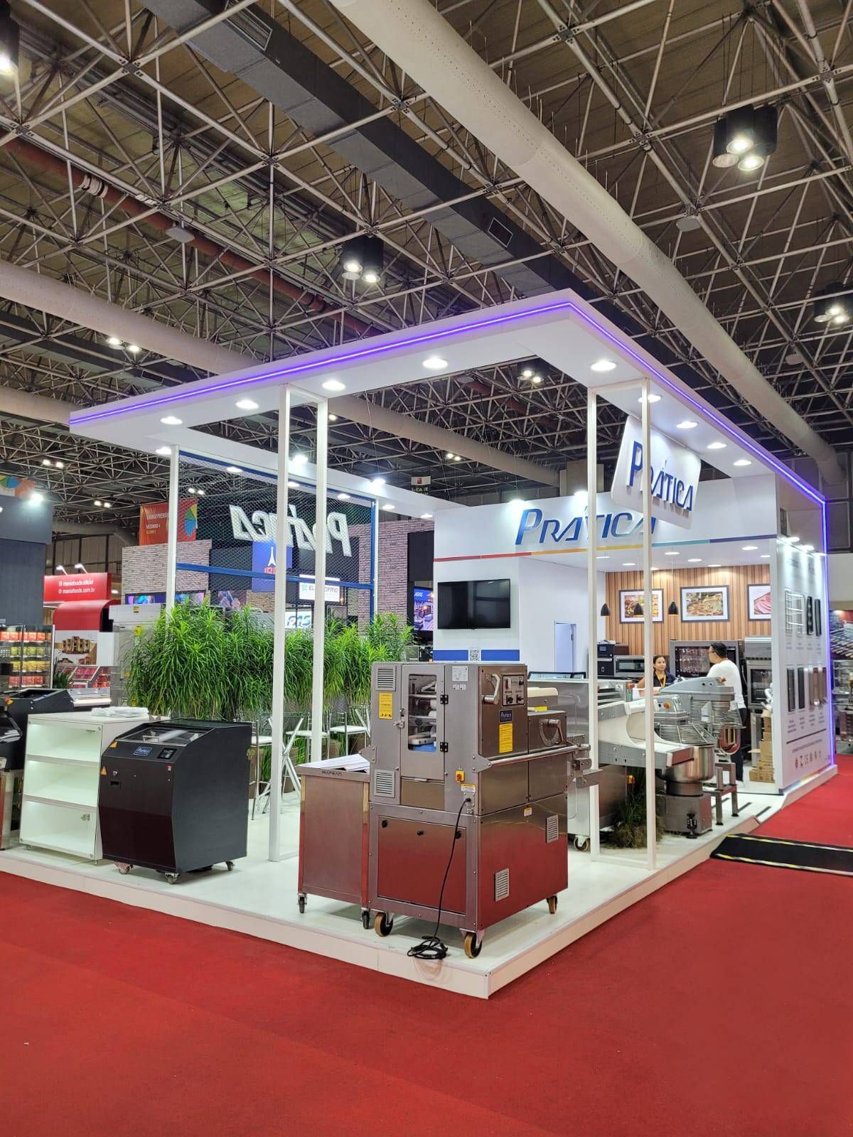 Uma grande exposição interna com tapete vermelho e muitas máquinas.