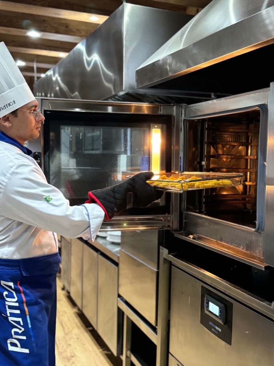 Um chef está colocando uma bandeja de comida no forno.