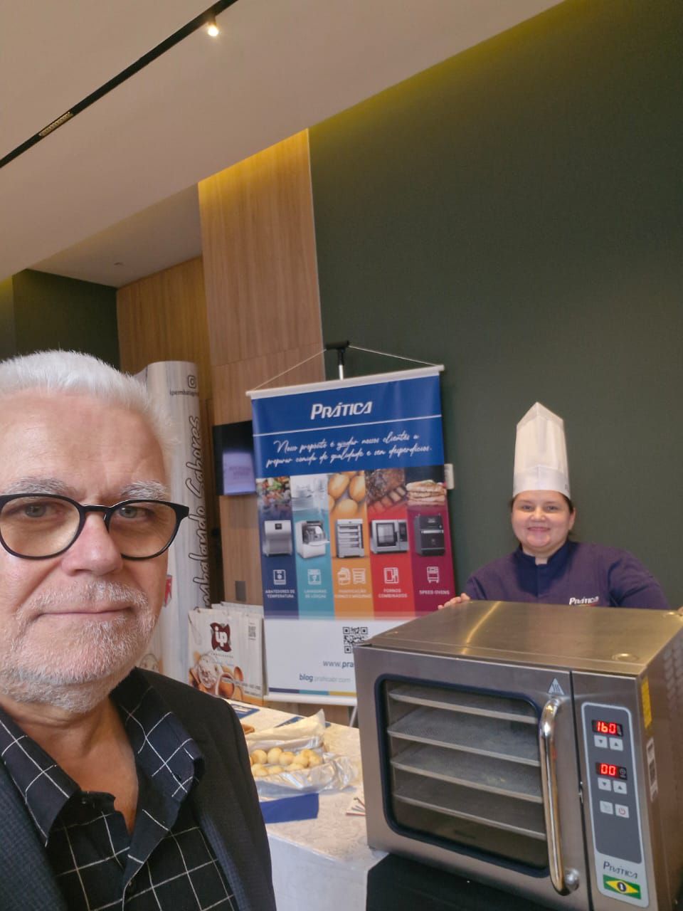 Um homem de óculos está em frente a um forno de micro-ondas