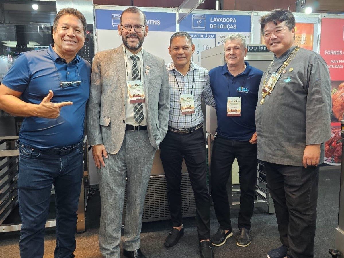 Um grupo de homens está posando para uma foto em uma sala.