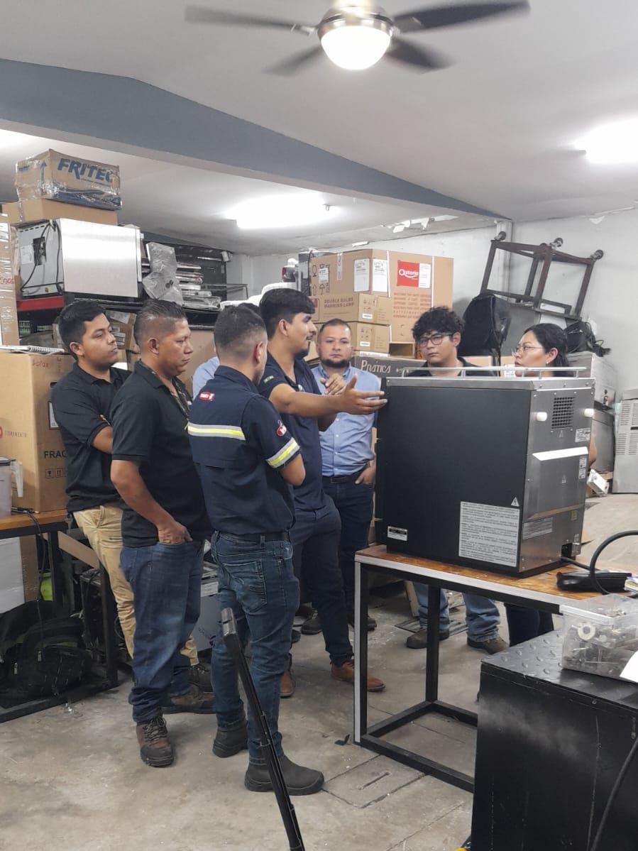 Um grupo de homens está em volta de um computador em uma sala.