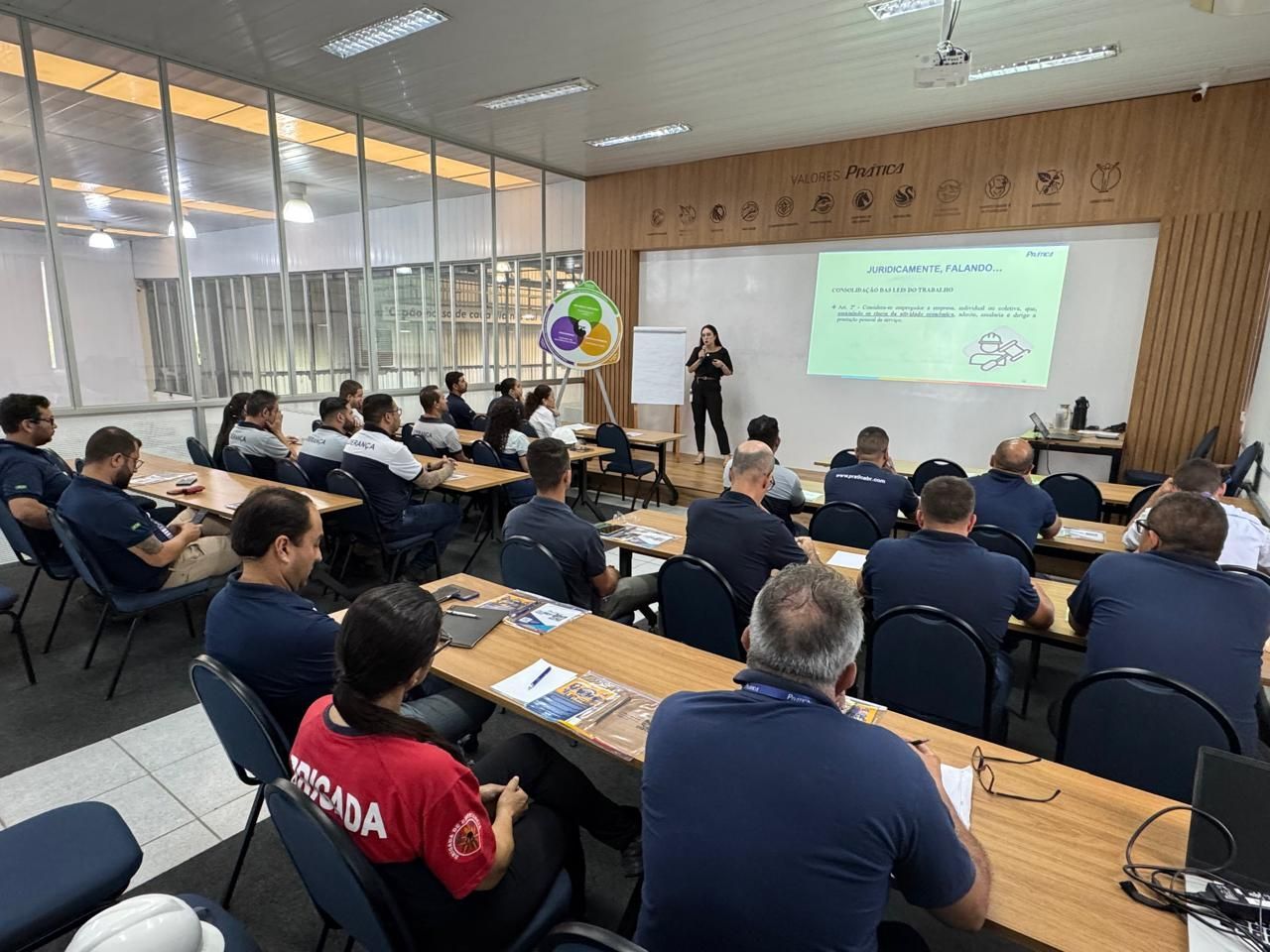Um grupo de pessoas está sentado em mesas em uma sala de aula.