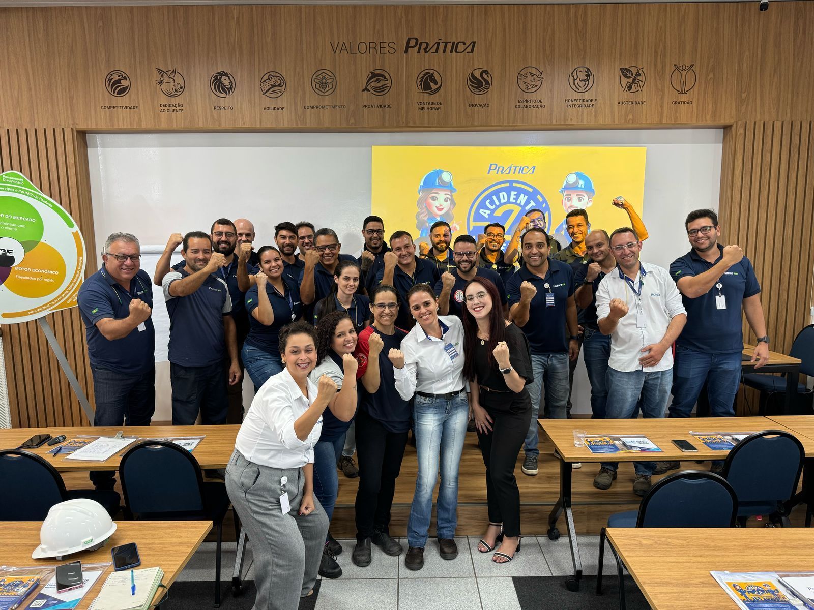Um grupo de pessoas está posando para uma foto em uma sala de aula.