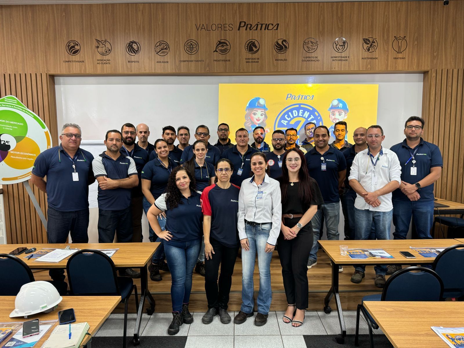 Um grupo de pessoas está posando para uma foto em uma sala de aula.