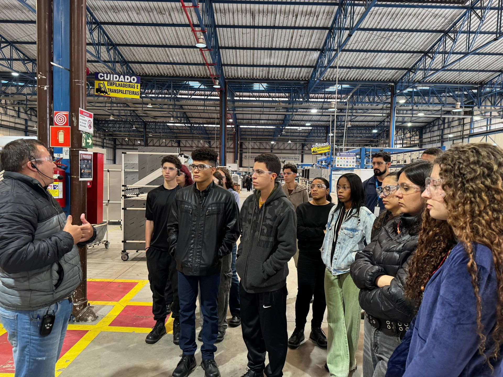 Um homem está conversando com um grupo de pessoas em um armazém.