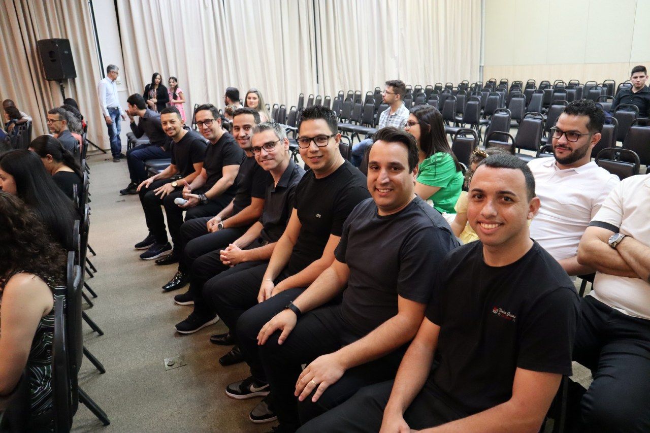 Um grupo de pessoas está sentado em cadeiras em uma sala.