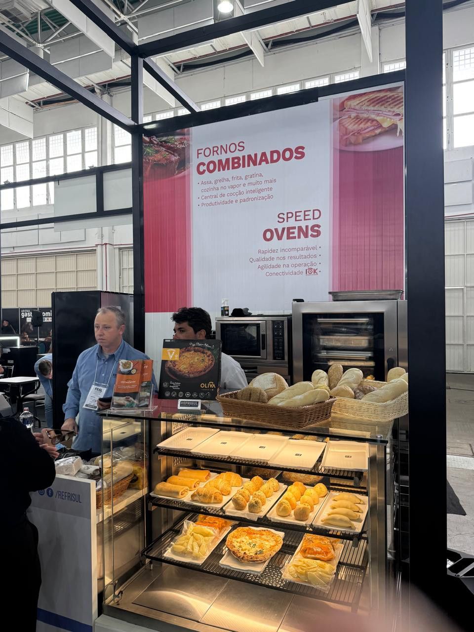 Um homem está parado em frente a uma vitrine cheia de comida.