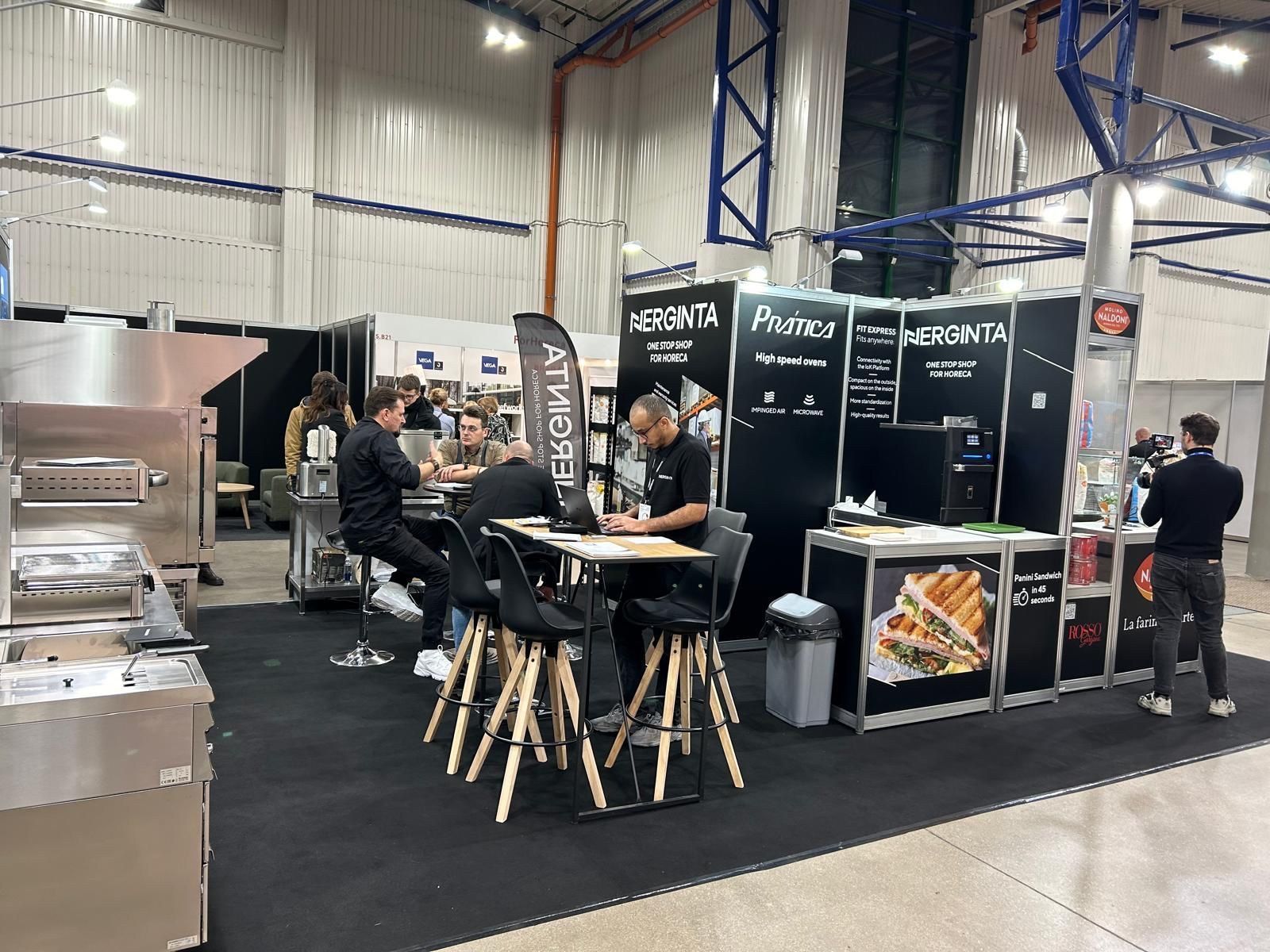 Um grupo de pessoas está sentado em mesas em uma sala.