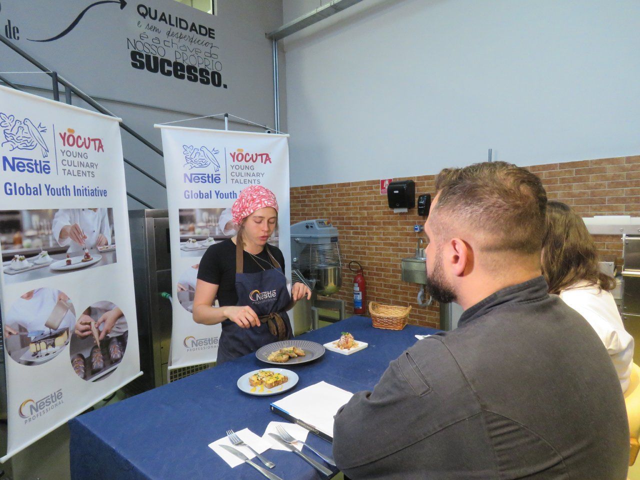Um homem e uma mulher estão sentados à mesa com pratos de comida.