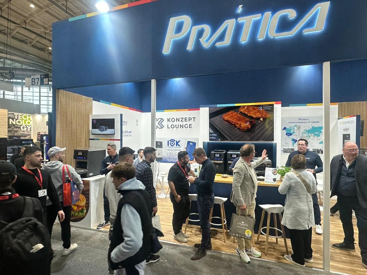 Um grupo de pessoas está em volta de um estande em uma convenção.