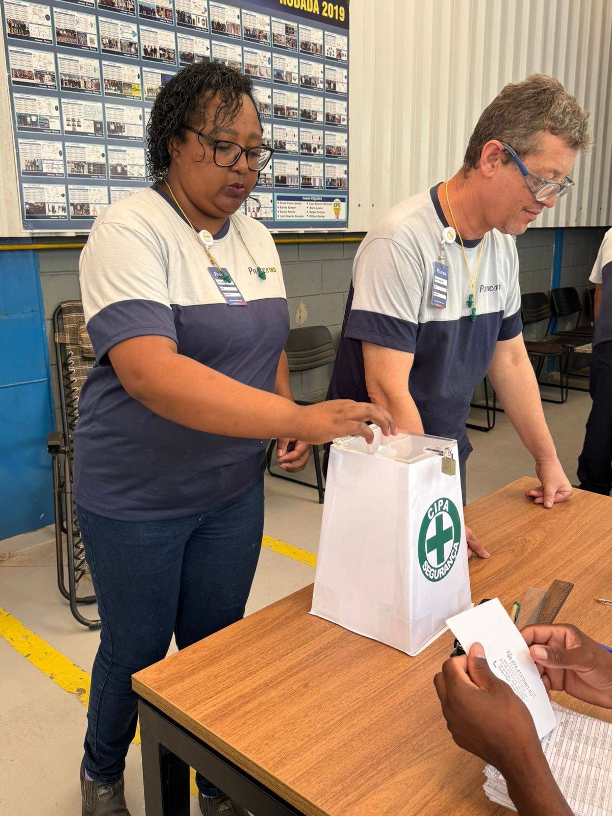 Um homem e uma mulher estão de pé em uma mesa com uma sacola em cima dela.