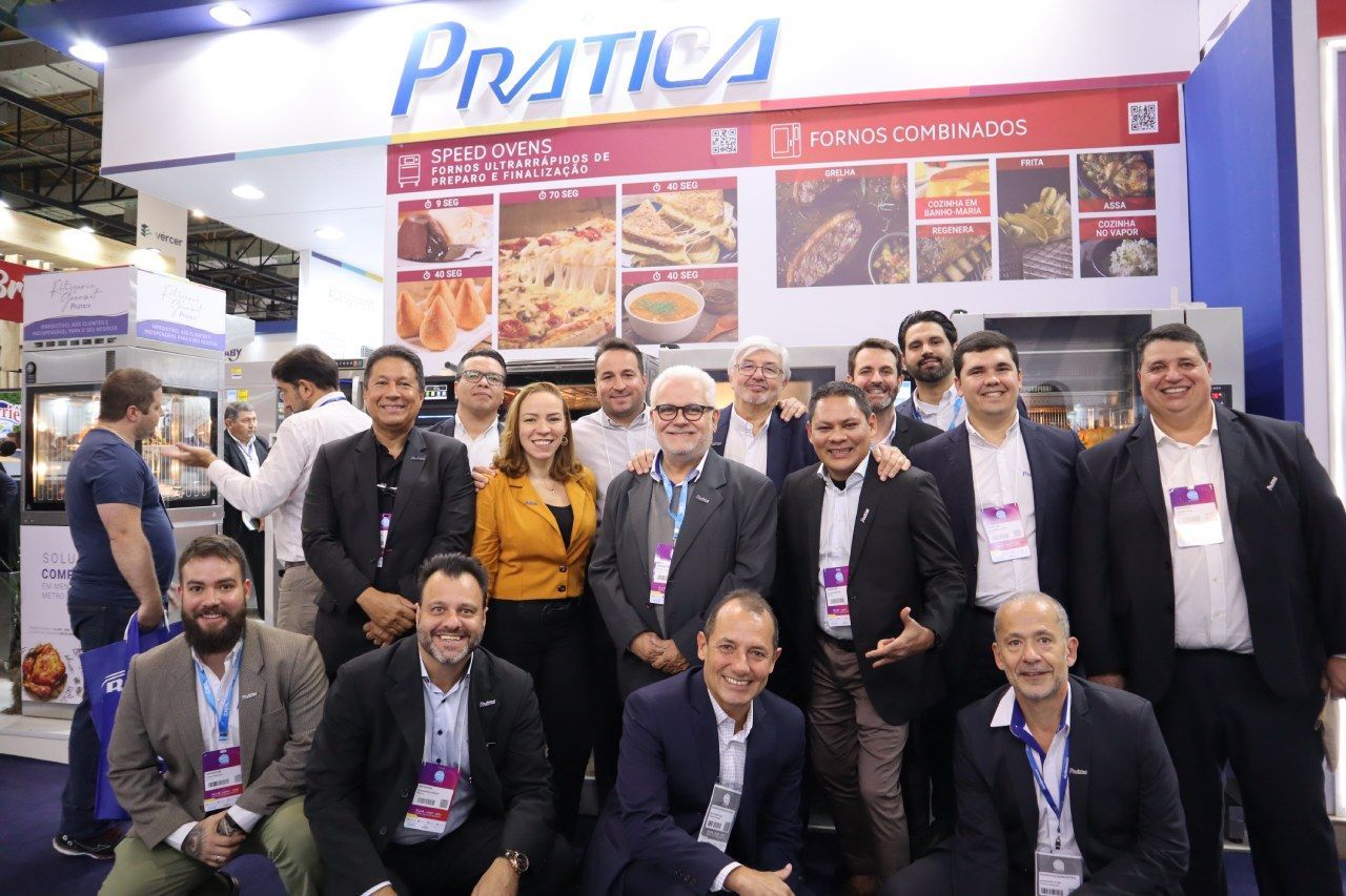 Um grupo de pessoas está posando para uma foto em uma convenção.