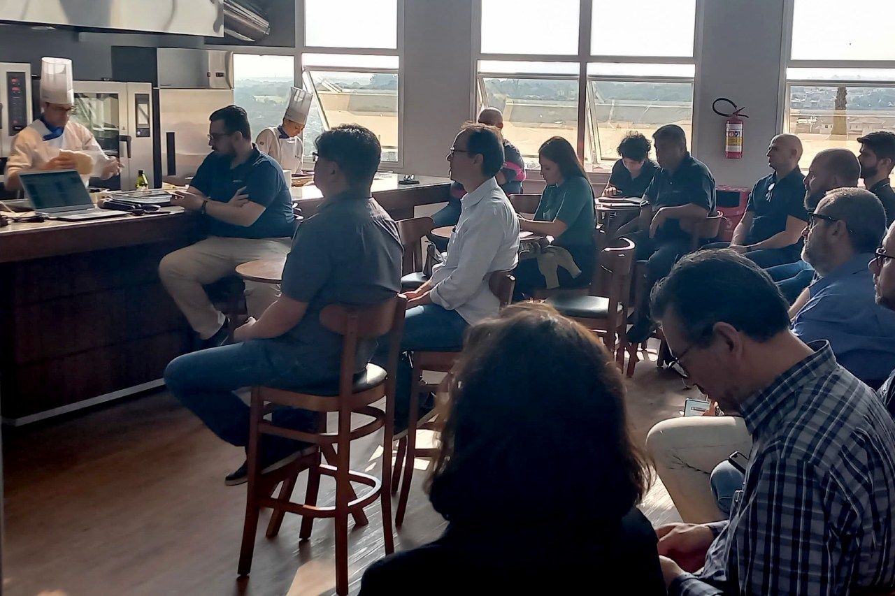 Um grupo de pessoas está sentado em um restaurante assistindo a uma apresentação.