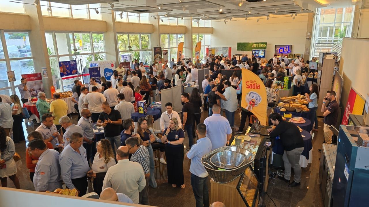 Um grande grupo de pessoas está reunido em uma sala grande.