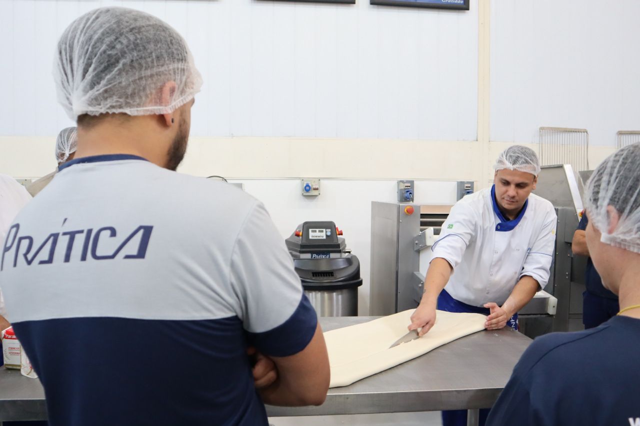 Um homem vestindo uma camisa prática está parado em uma cozinha
