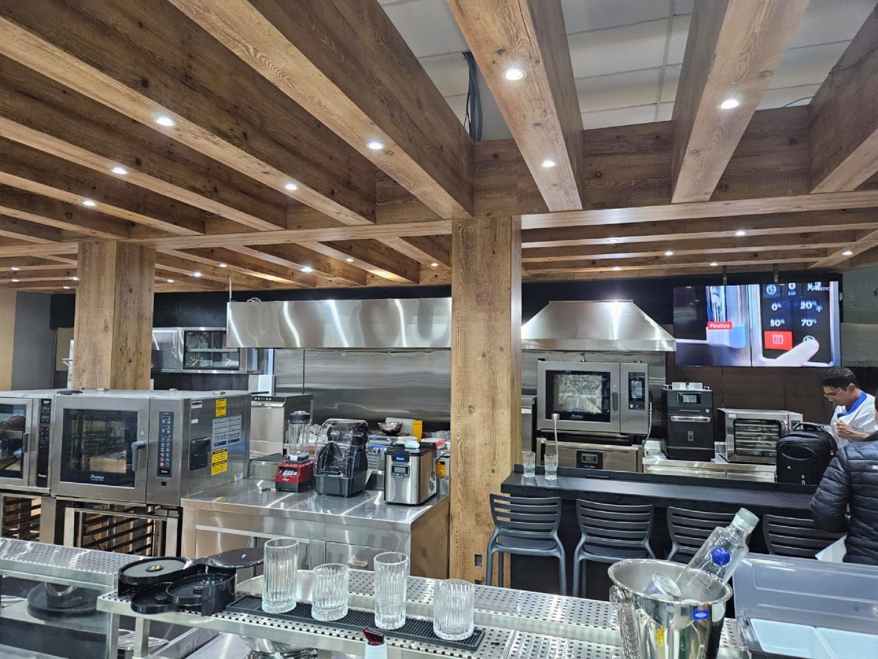 Uma cozinha com eletrodomésticos de aço inoxidável e vigas de madeira.