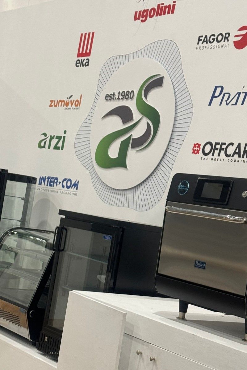 Uma parede com muitos logotipos e muitos eletrodomésticos em exposição.