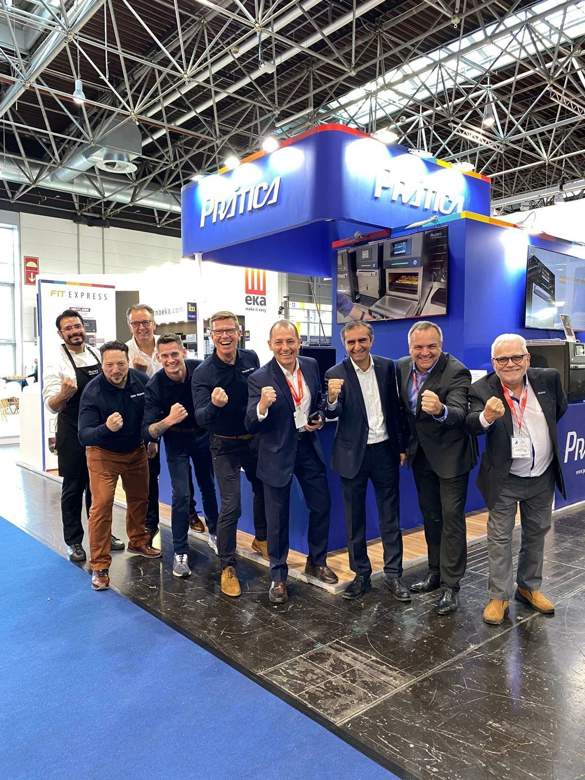 Um grupo de homens está posando para uma foto em frente a um estande em uma convenção.