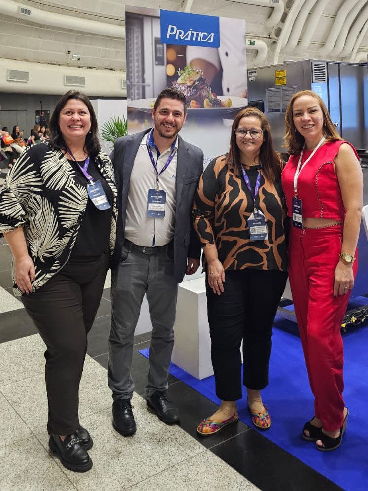 Um grupo de pessoas está posando para uma foto em uma convenção.