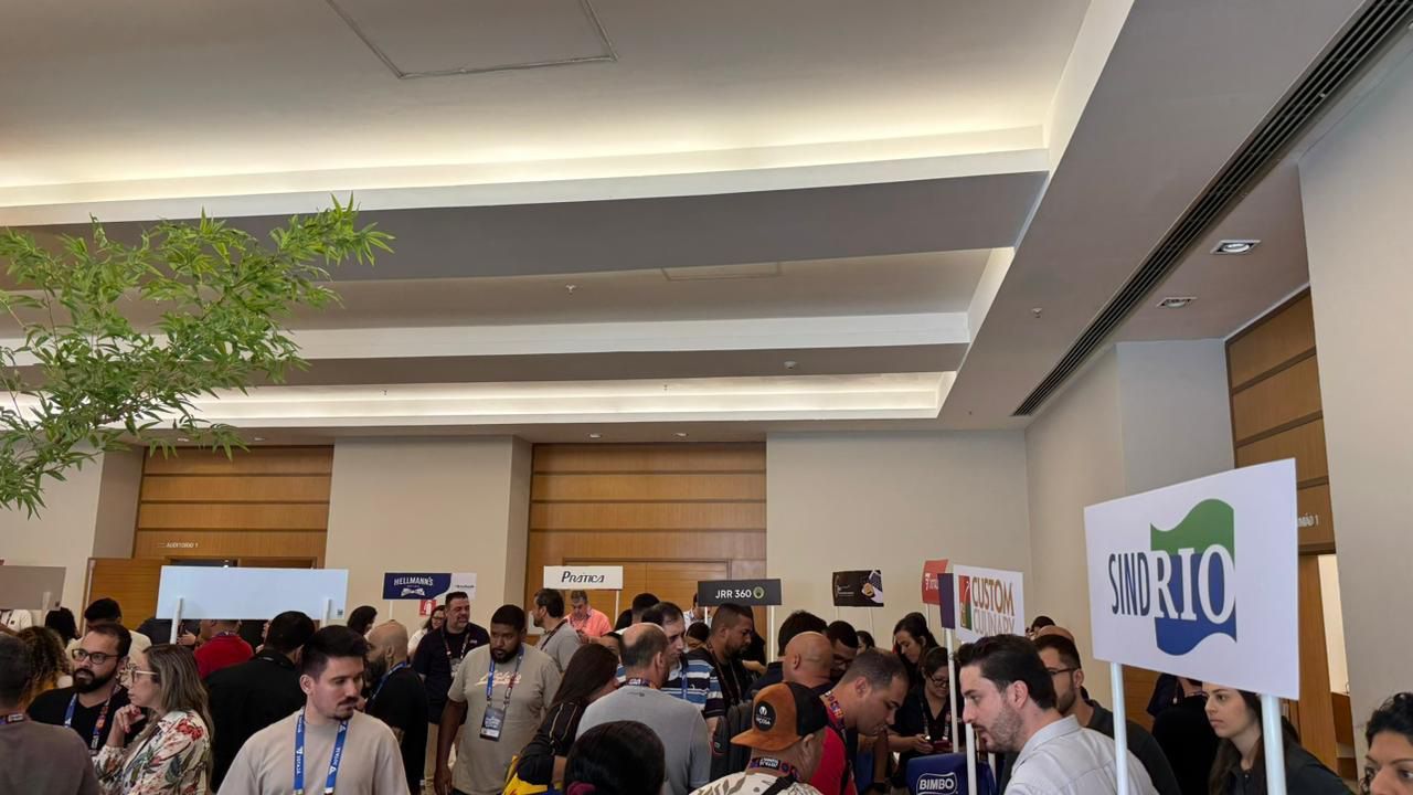 Um grande grupo de pessoas está reunido em uma sala.