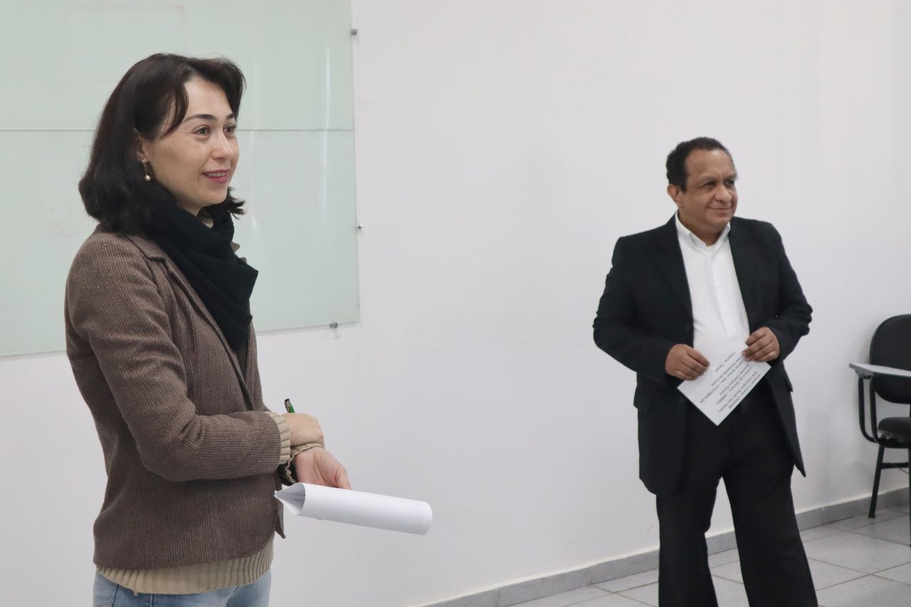 Um homem e uma mulher estão parados um ao lado do outro em uma sala