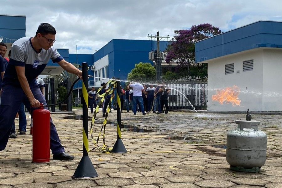 Um homem está usando um extintor de incêndio para apagar um incêndio.