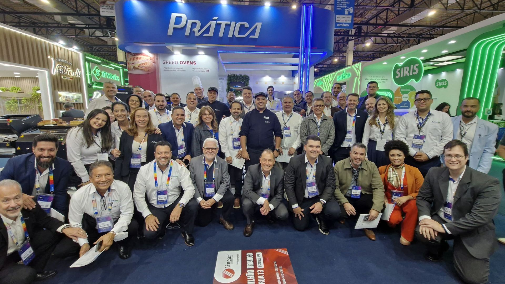 Um grupo de pessoas está posando para uma foto em uma convenção.