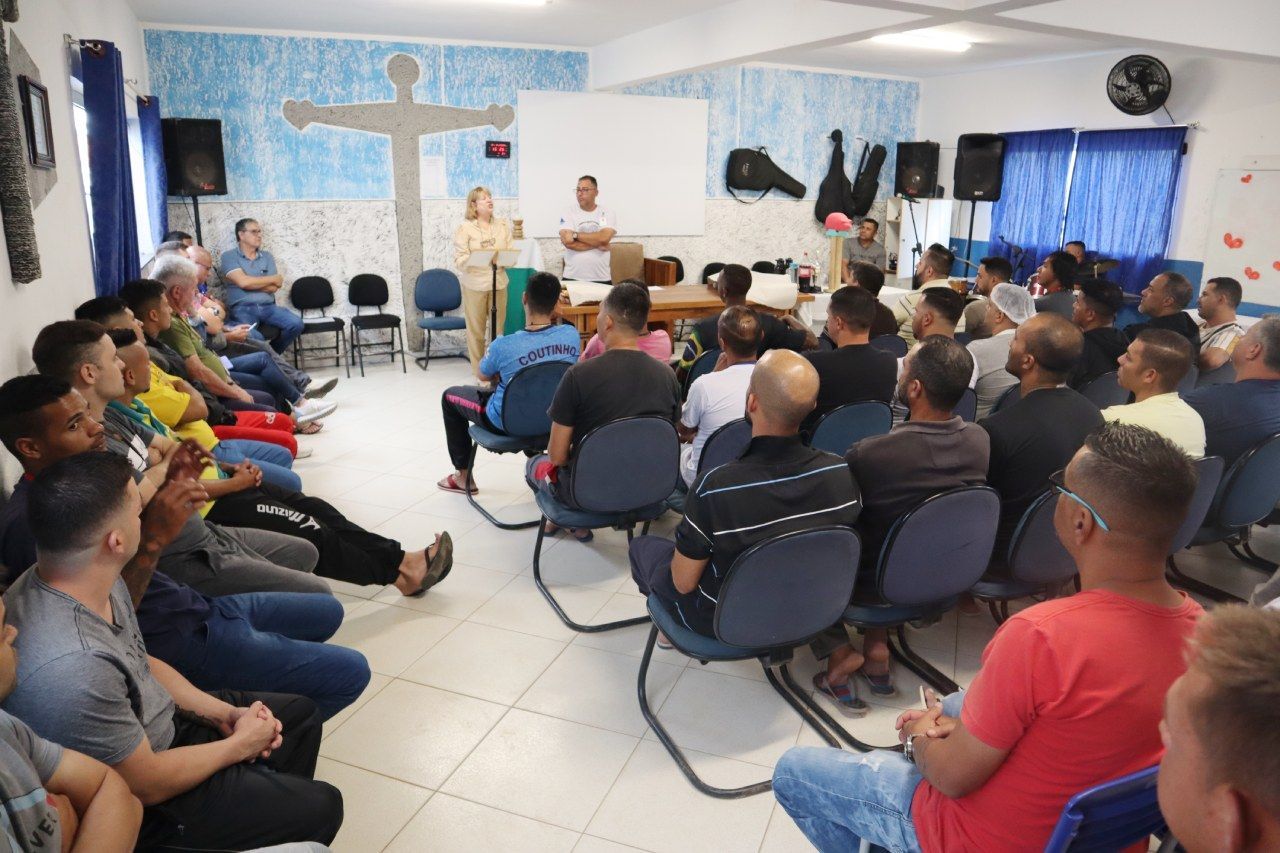 Um grupo de pessoas está sentado em cadeiras em uma sala.