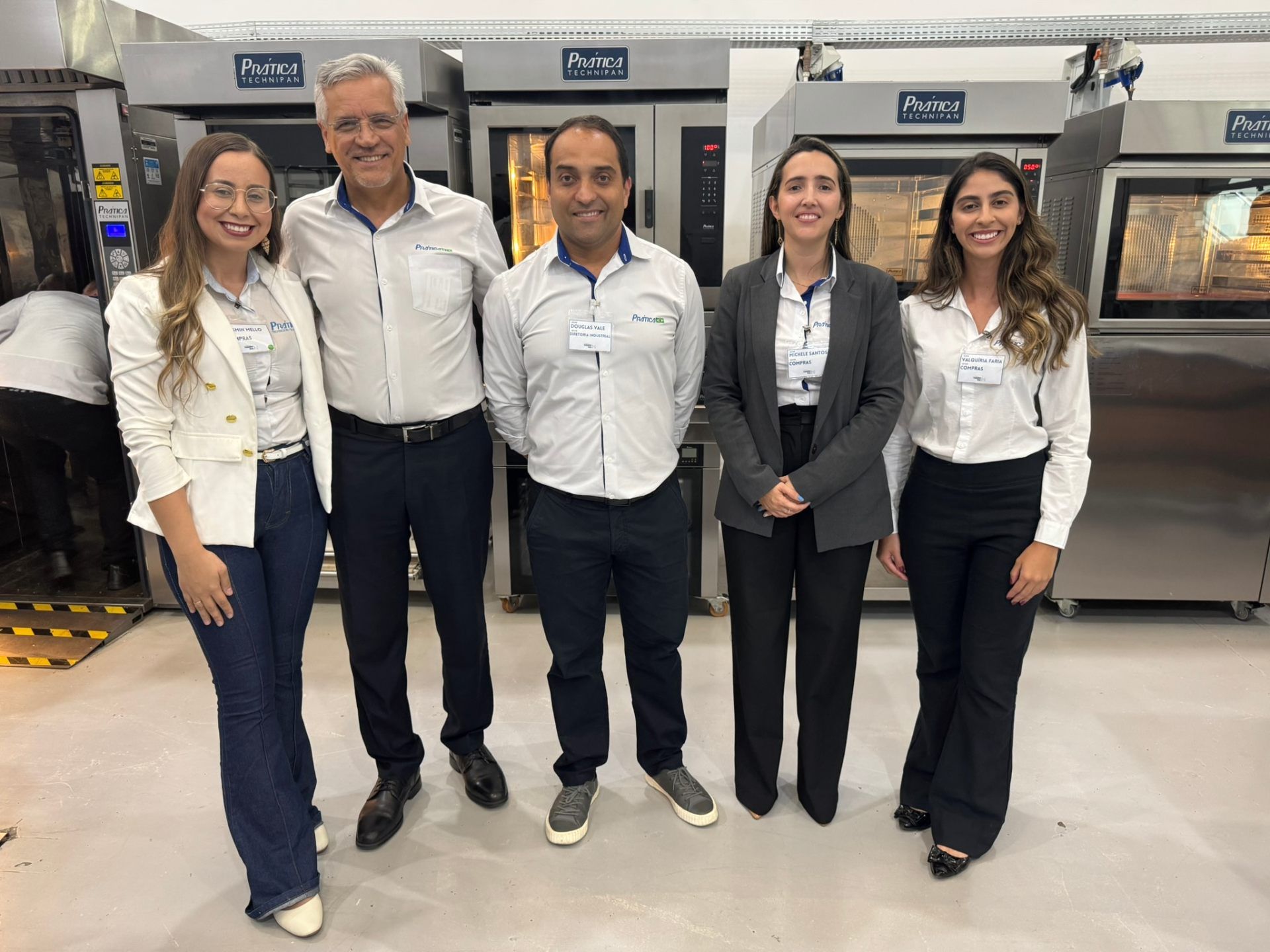 Um grupo de pessoas está posando para uma foto em uma cozinha.