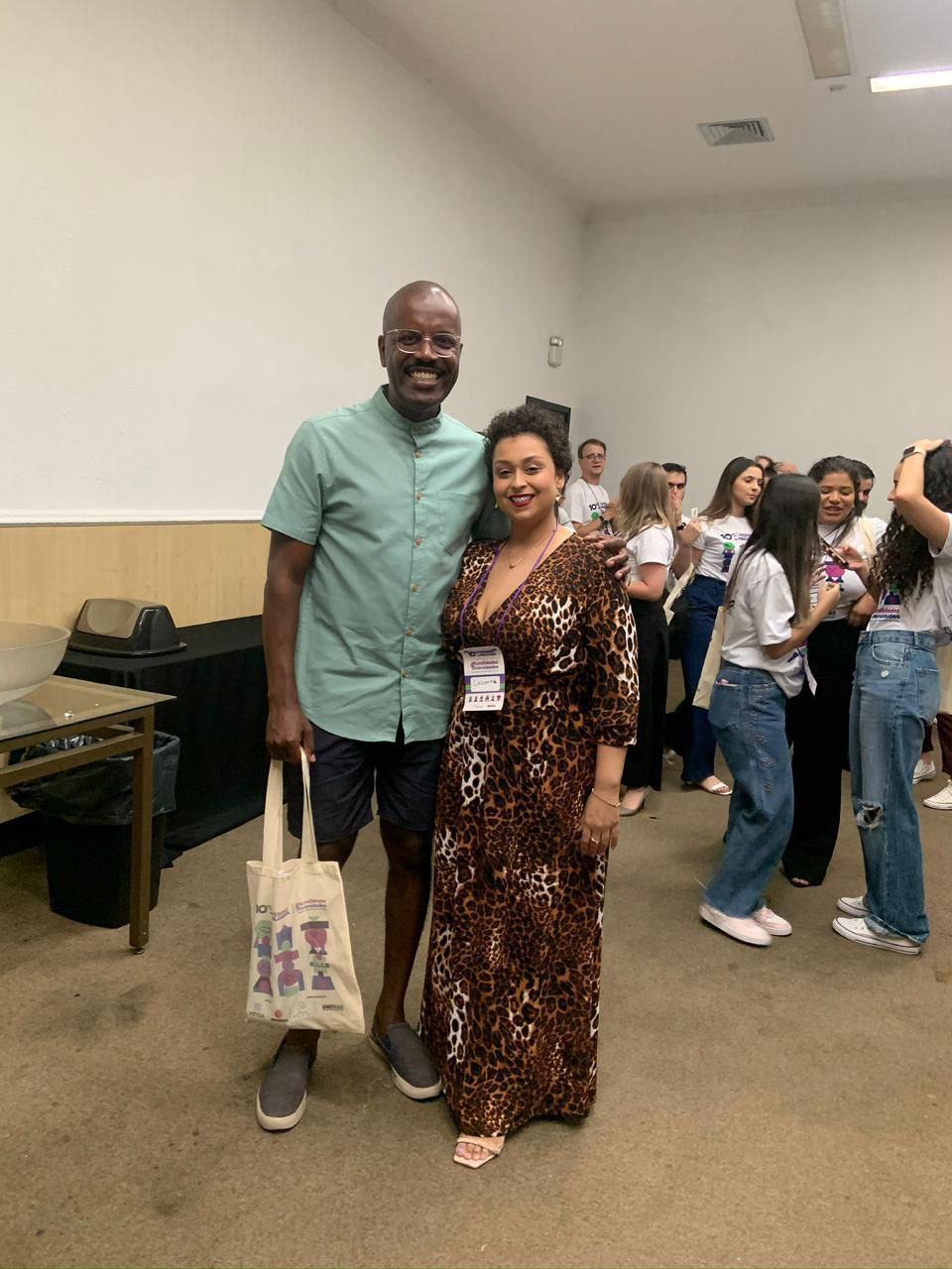 Um homem e uma mulher estão posando para uma foto em uma sala.