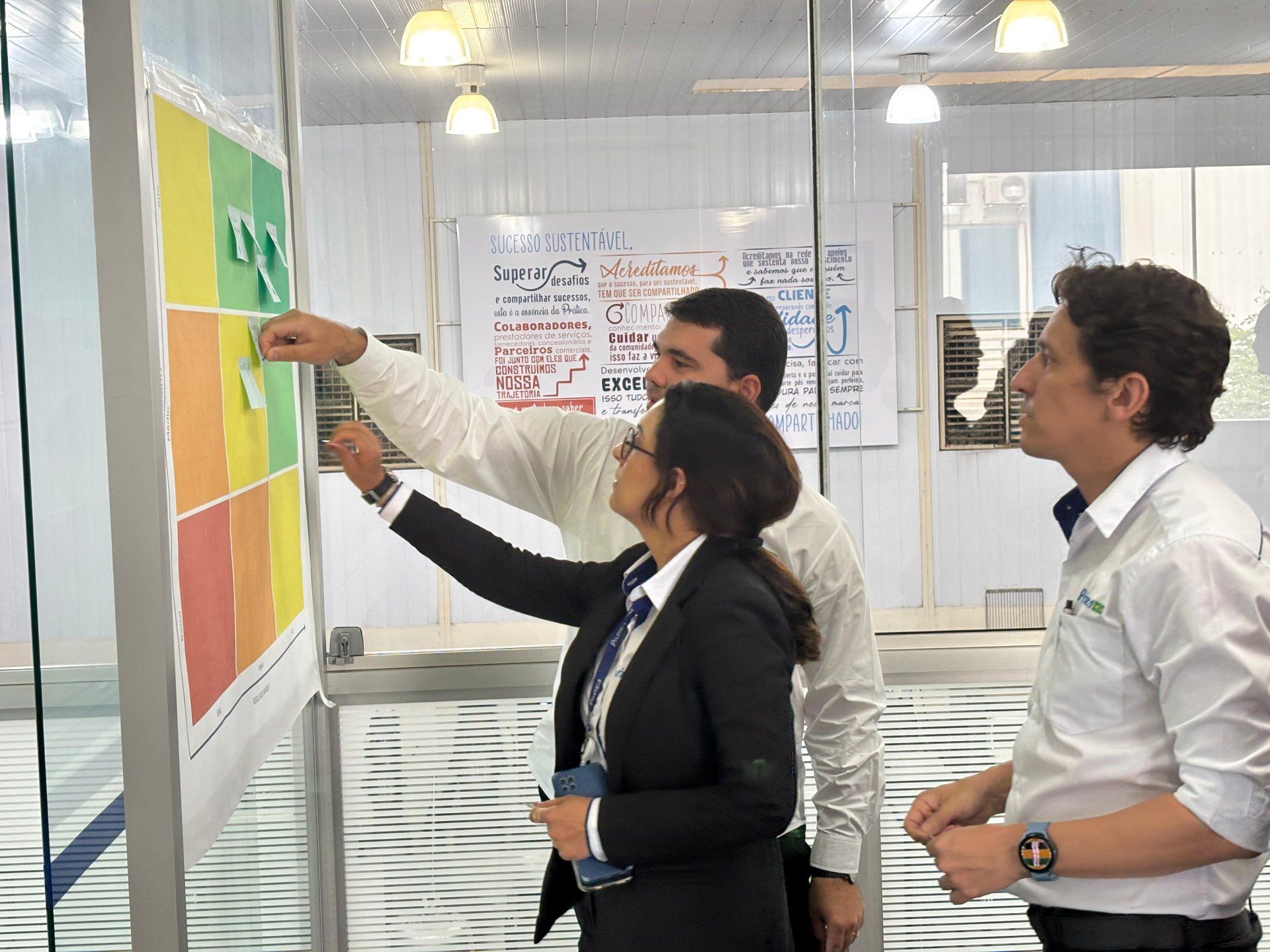 Um grupo de pessoas está olhando para um gráfico na parede.