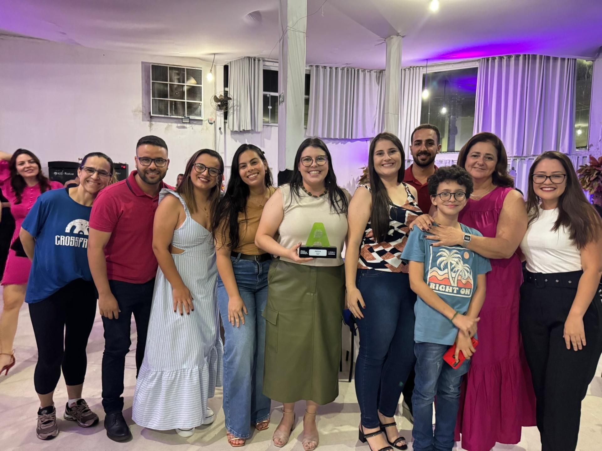 Um grupo de pessoas está posando para uma foto em uma sala.