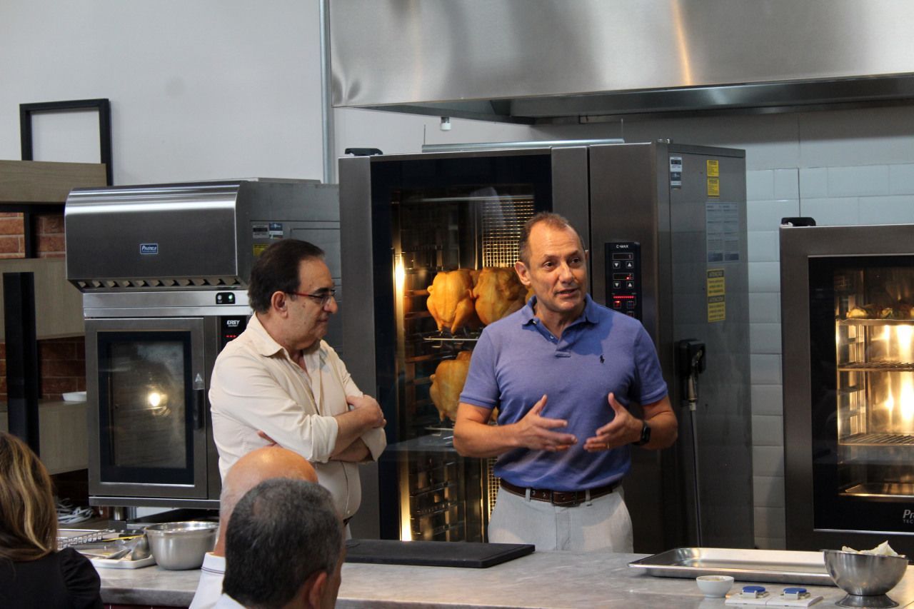 Dois homens estão em uma cozinha conversando um com o outro