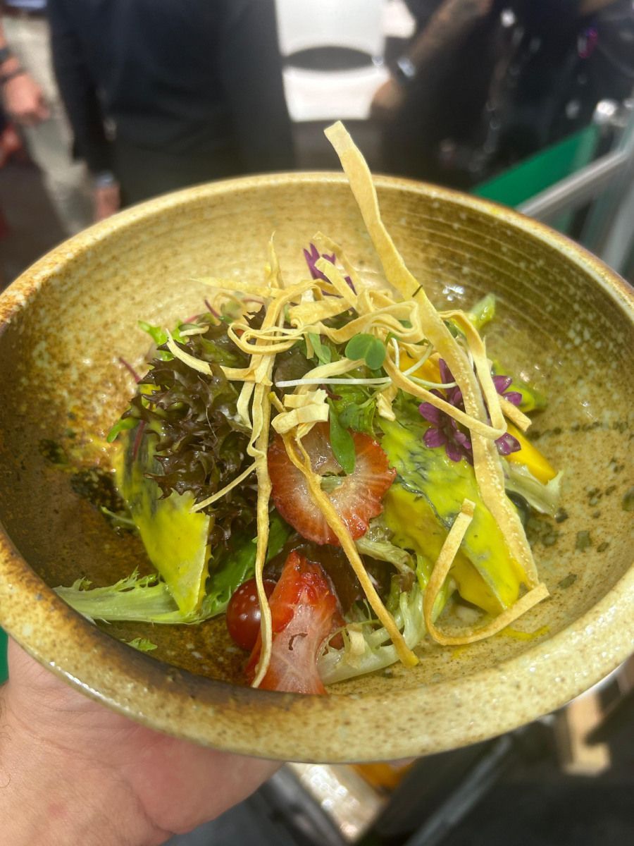 Uma pessoa está segurando uma tigela de salada na mão.