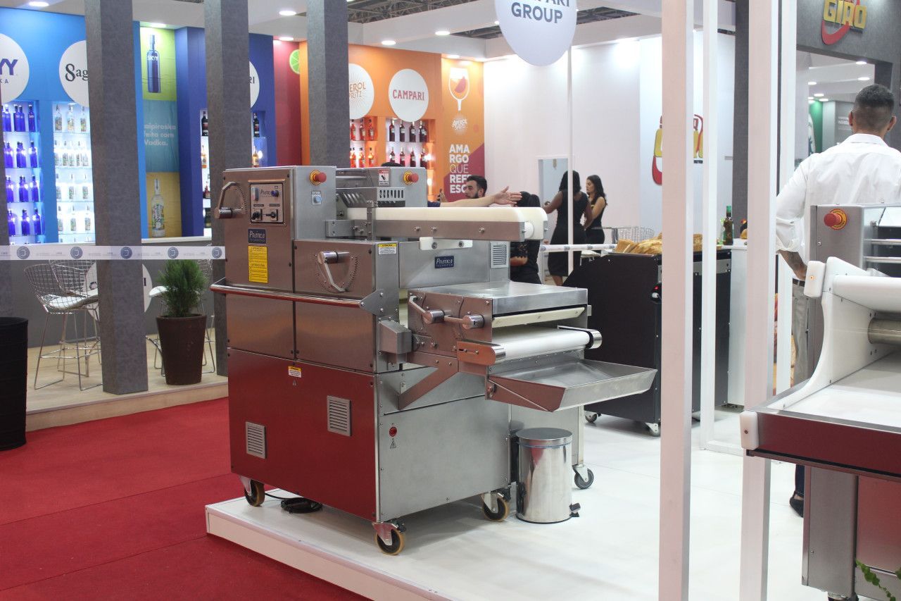 Uma máquina está exposta em uma sala com tapete vermelho.