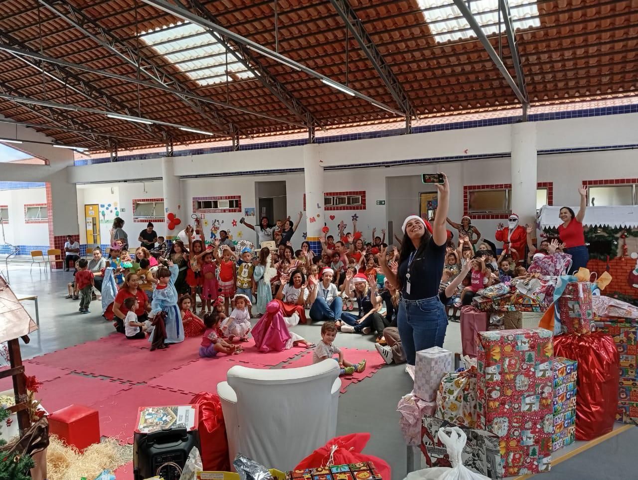 Um grupo de crianças está sentado no chão em uma sala grande.