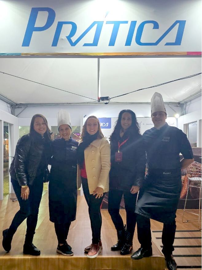 Um grupo de pessoas em pé na frente de uma placa de prática