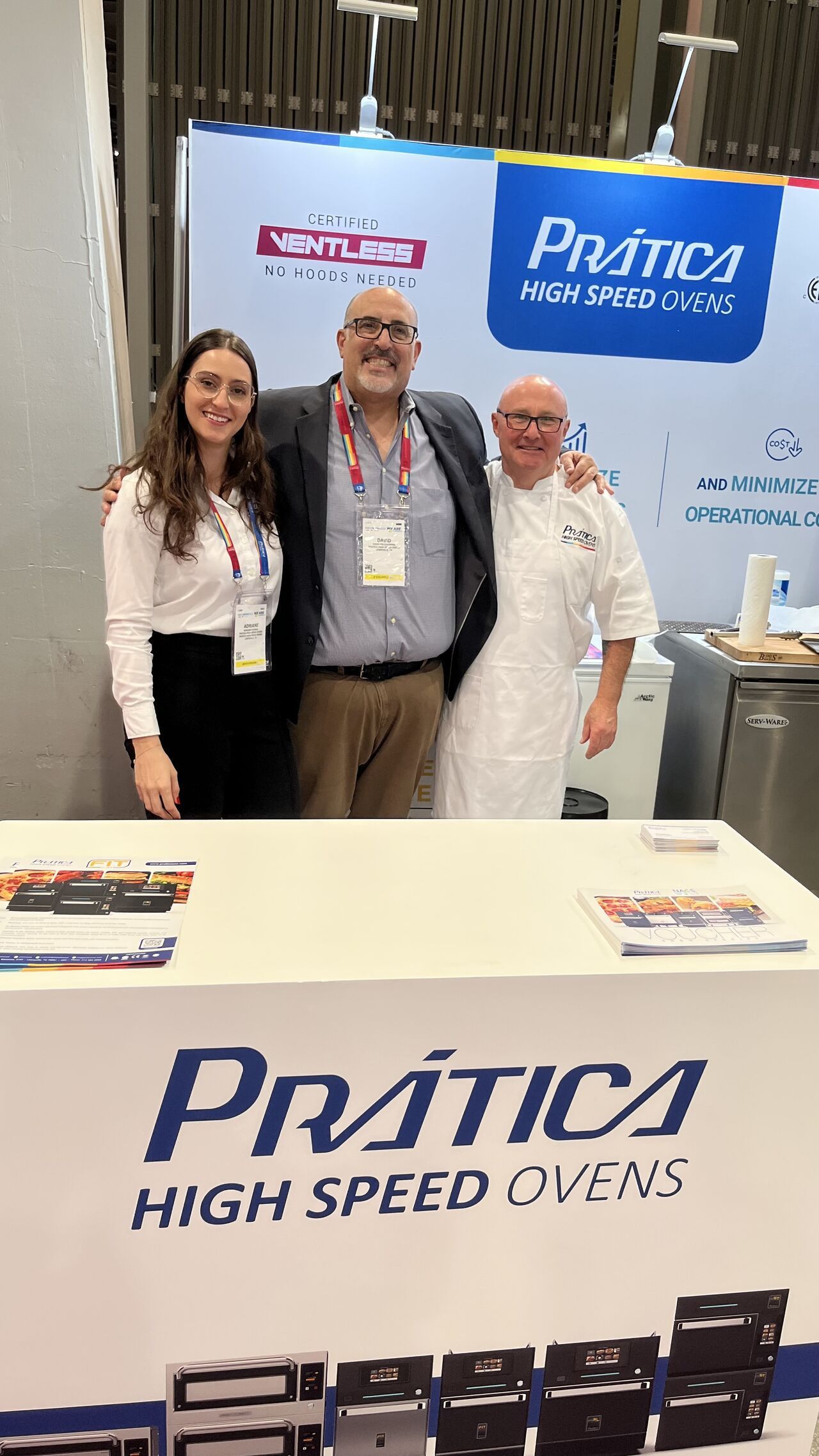 Um grupo de pessoas está posando para uma foto em frente a uma mesa.