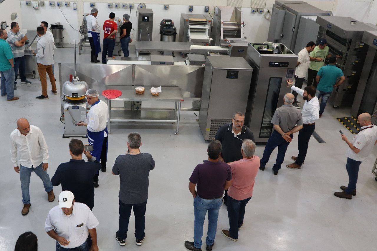 Um grupo de homens está em uma cozinha conversando entre si