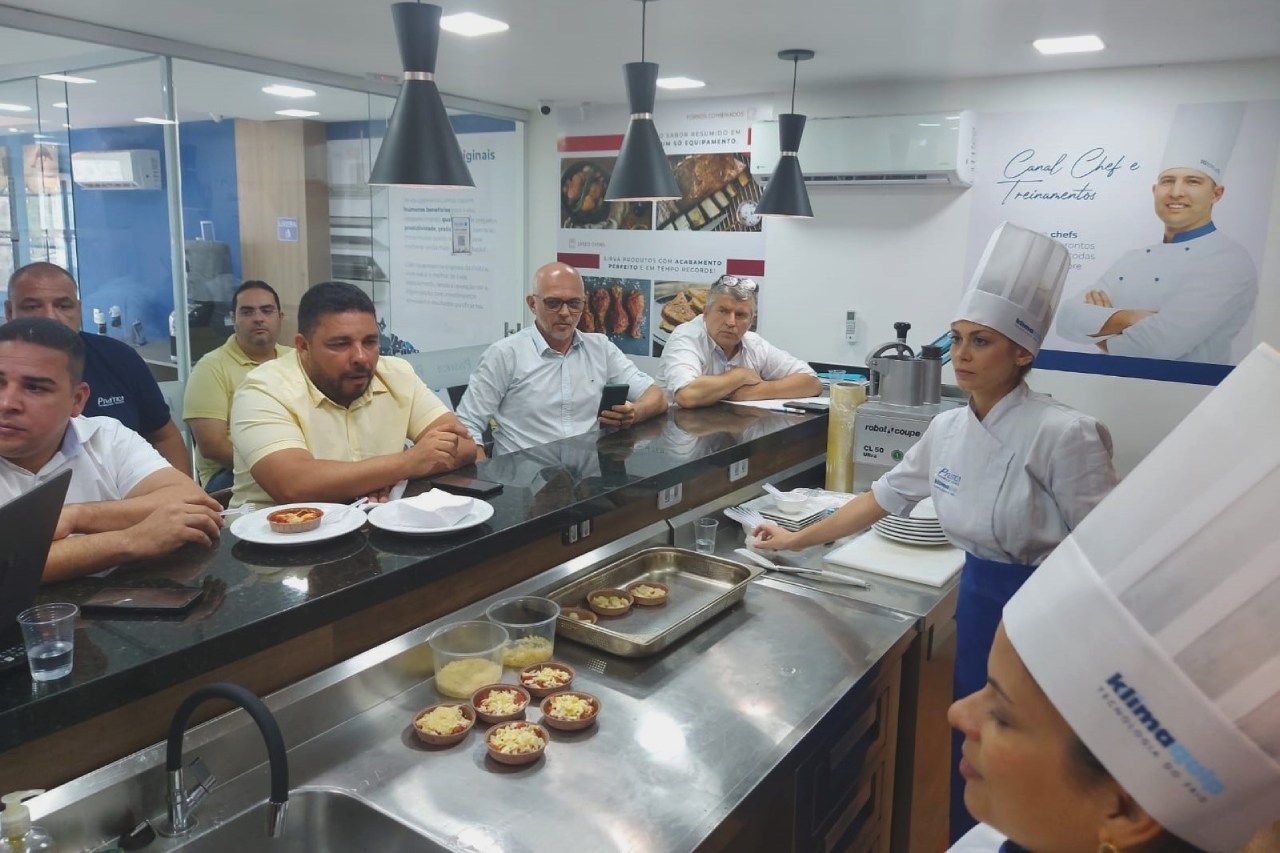 Um grupo de pessoas está sentado em um balcão na cozinha.