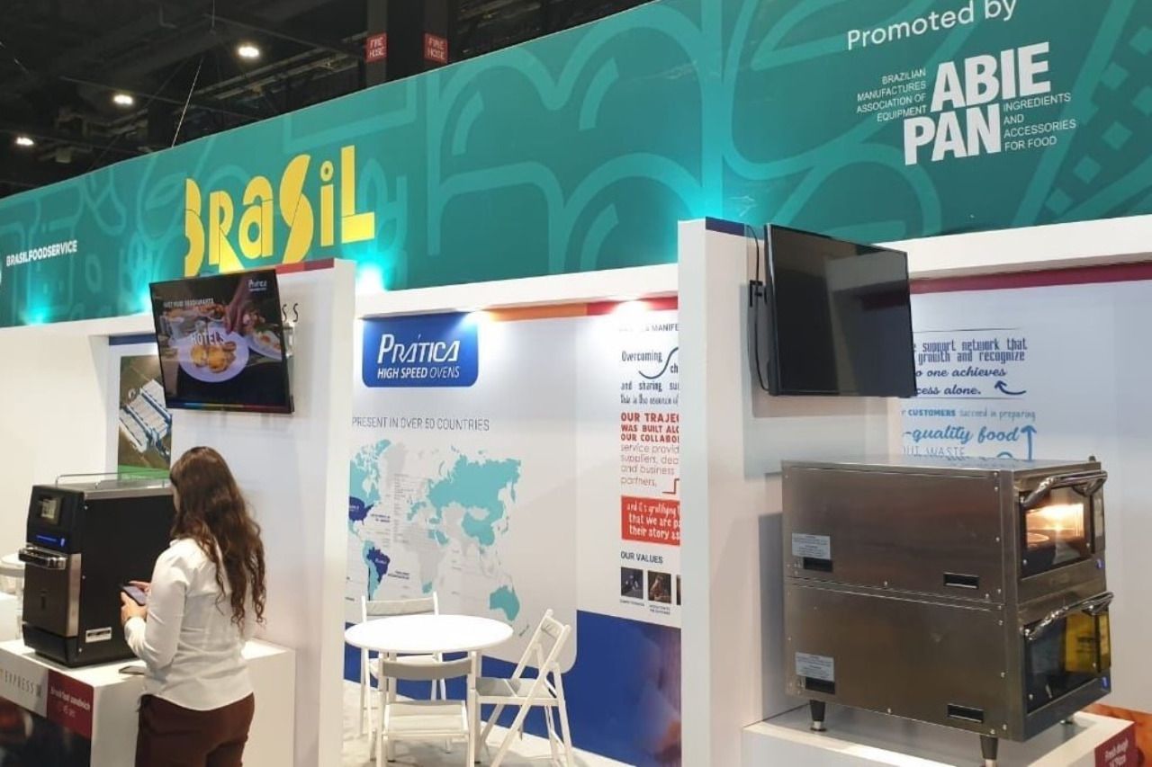 Uma mulher está parada em frente a uma barraca que diz brasil