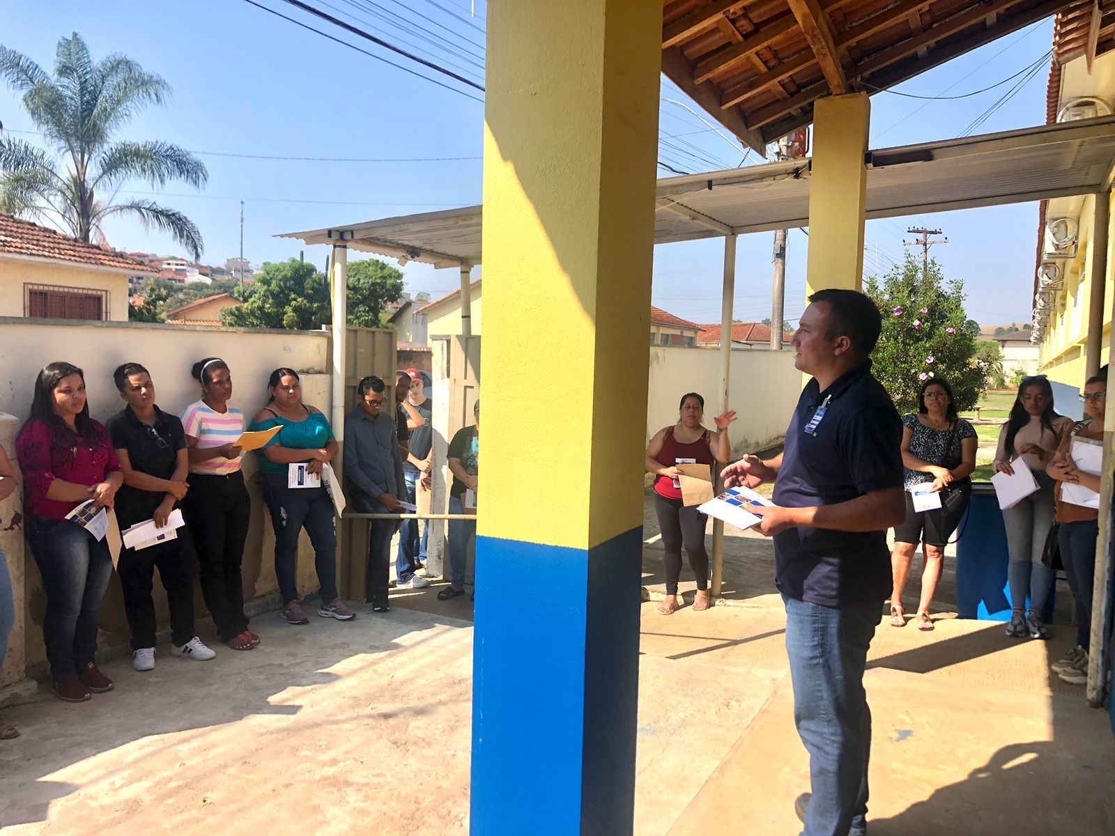 Um homem está parado na frente de um grupo de pessoas.